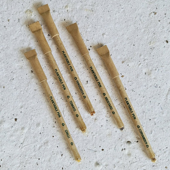 Plantable seed pens made with recycle paper with brown cap and live seeds at back side