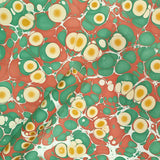 handmade paper with marbling made of red, green and golden colours 